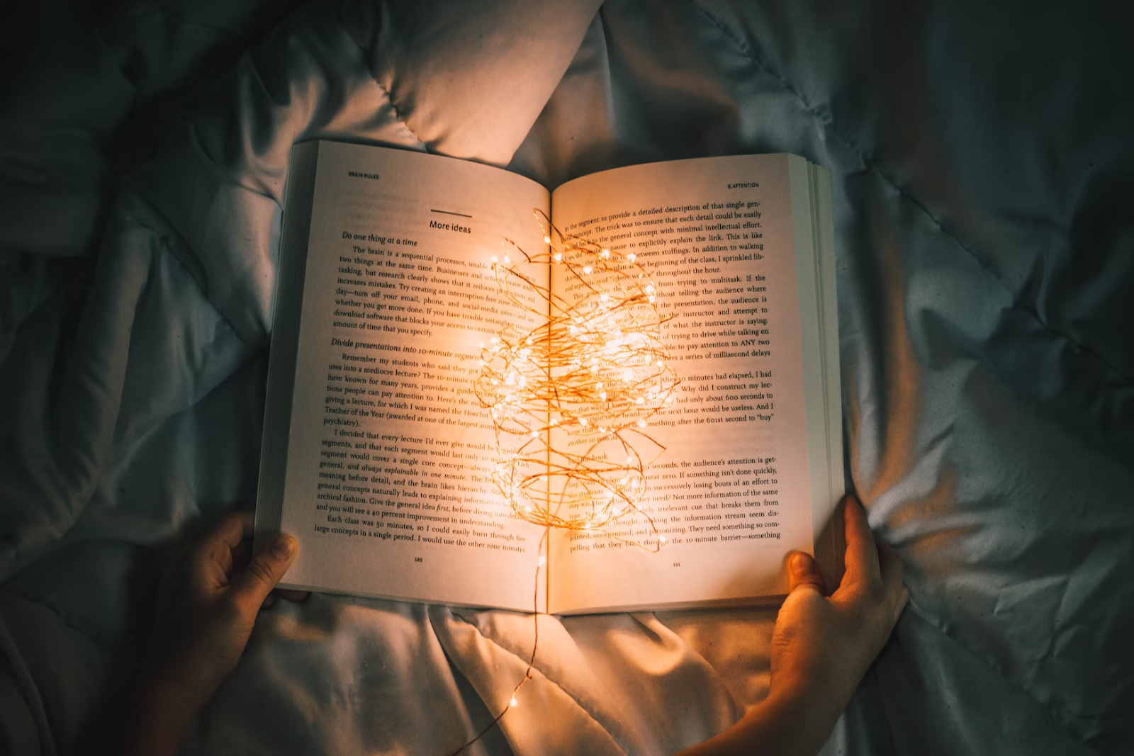 an open book with fairy lights illuminating the pages