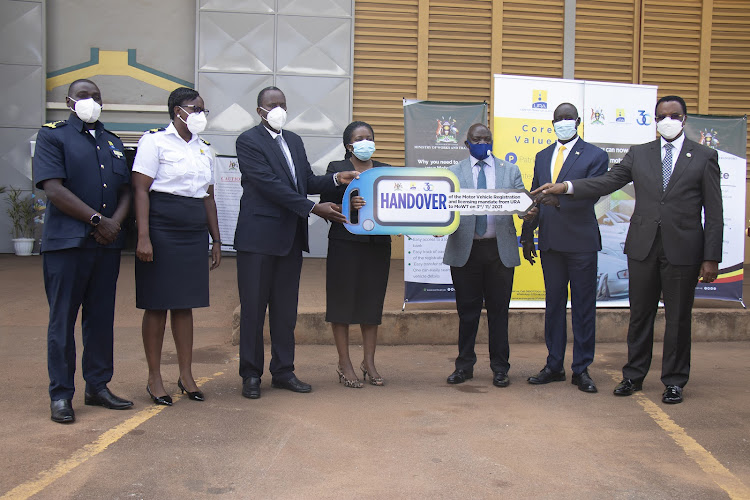 URA Commissioner General John Musinguzi Rujoki hand over a commemoration key to Works Minister Gen Edward Katumba Wamala.