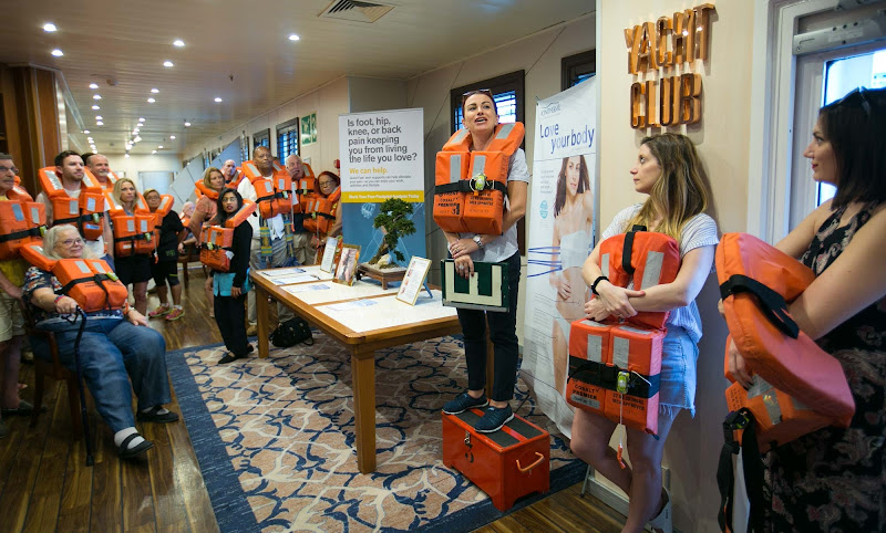 Adriana, the ship's casino manager who hails from Romania, offers instruction during a muster drill on Wind Surf. 