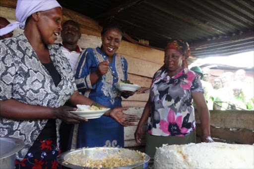 Thika town MP Alice Ng'ang'a with women from Kiandutu when she launched the Huduma Jiko program on Tuesday. the jikos operated by women groups will provide food for workers in the ongoing slum upgrade project.