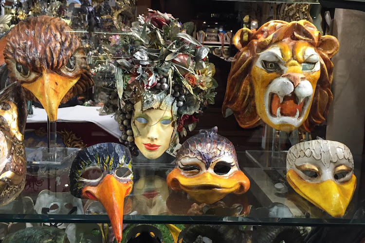 Traditional Venetian masks in a shop window along the Procuratie Vecchie on Piazza San Marco, Venice. 