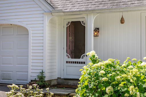 White front door with flower garden in this luxury house for sale in Norfolk Historic District ($749,000)