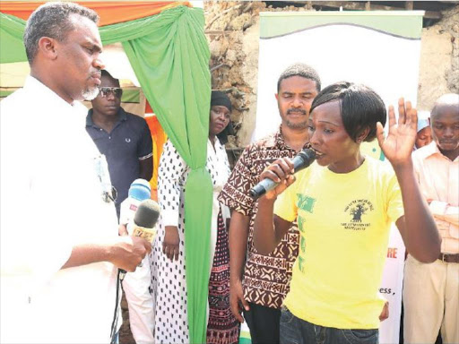 DPP Noording Haji listens to residents of Dunga Unuse slum Florence Awour during the launch of Changamwe Social Justice Centre at Chaani in Changamwe, Mombasa on Wednesday. /ANDREW KASUKU