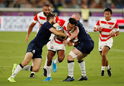 Japan's Kotaro Matsushima is tackled by Scotland's Tommy Seymour and Stuart Hogg.