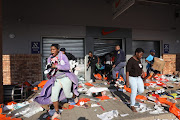 People looting in Durban flee from a police officer on July 12 2021. 