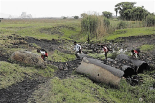 RISKY: In the absence of a bridge over a stream in Delpark Extension 4 near Delmas in Mpumalanga, Delpark Primary School pupils climb over damaged pipes to get to school PHOTO: ANTONIO MUCHAVE