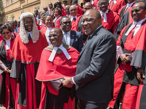 President Uhuru Kenyatta shares a light moment with Lady Justice Roselyn Naliaka Nambuye at the Supreme Court grounds. /PSCU