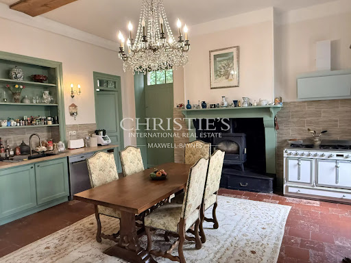 Dining room with kitchen and fireplace in this luxury manor for sale in Saint-Justin ($1,134,103 - 909 m²)