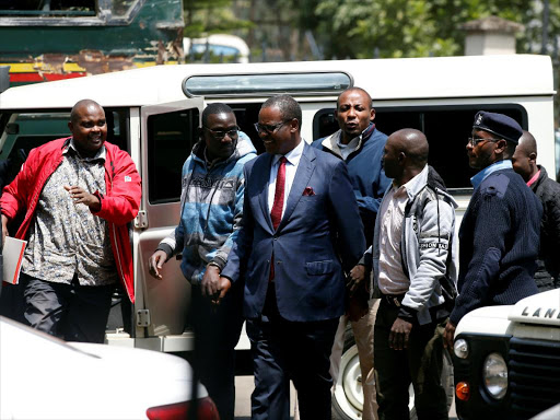 Evans Kidero (centre) is escorted by police as he arrives to face charges over suspicion of corruption-related crimes at the Milimani Court in Nairobi, Kenya on August 9, 2018.