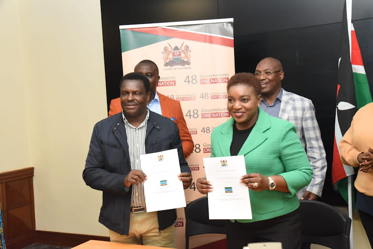 County of Governors Health Committee chairperson Muthomi Njuki and Health CS Susan Wafula display the signed Intergovernmental Participation Agreement on June 15, 2023.