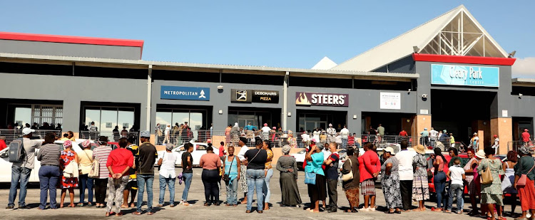 People queue at the Cleary Park shopping centre to access their Sassa grants to buy basic foods