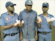 GOTCHA: Inspector Lazarus Msiza, left, and Captain Carter Monoge, right, of the Macadamia Border line flank a fake cop arrested on Tuesday. Pic: ANDREW HLONGWANE.  13/10/2009. © Sowetan.