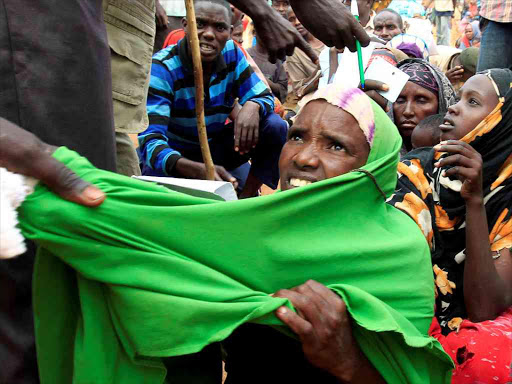 A newly arrived Somali refugee is forced out of the queue outside a reception centre in the Ifo 2 refugee camp in Dadaab, near the Kenya-Somalia border, in Garissa county, Kenya July 28, 2011. /REUTERS