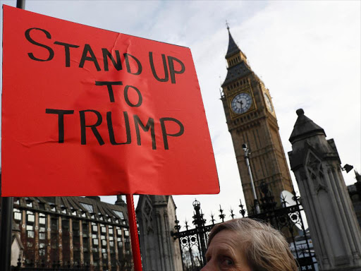 A demonstrator holds a banner that reads "Stand Up To Trump" outside The Houses of Parliament in London, Britain, February 20, 2017. /REUTERS