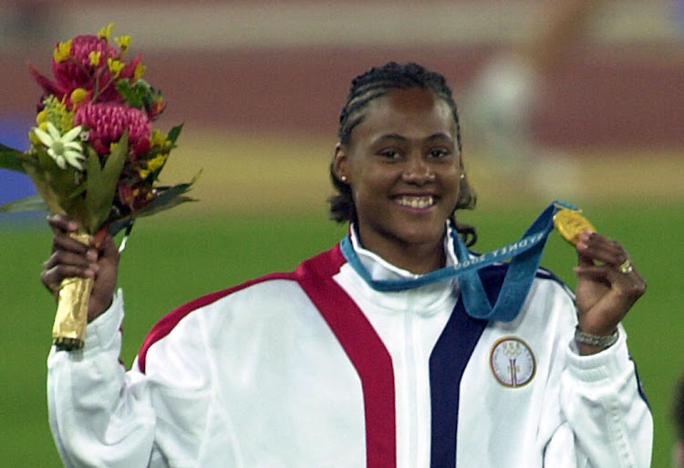 Marion Jones celebrates with her gold medal after victory in the Women's 100m Final during the 2000 Sydney Olympic Games at the Olympic Stadium, Sydney, Australia.