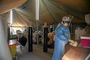 Professional healthcare workers in a tent dedicated to the treatment of possible Covid-19 coronavirus patients at the Tshwane District Hospital in Pretoria. 