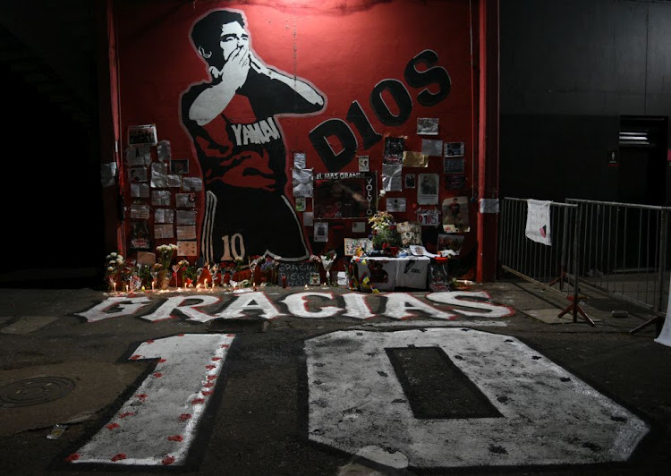 T-shirts, flowers and candles are offered to pay respects to Diego Maradona at Marcelo Bielsa Stadium in Rosario, Argentina, after the former player's on November 25 2020. Maradona, considered one of the biggest football stars in history, died at 60 from a heart attack on Wednesday in Buenos Aires.