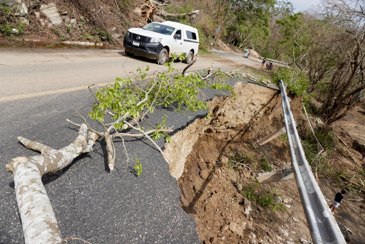 A car passes by a damaged road in the aftermath of Hurricane Agatha, in Zipolite, Oaxaca state, Mexico, June 1, 2022.