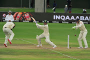 Quinton de Kock of the Proteas cuts with Ollie Pope of England and Jos Buttler of England fielding on day 3 of the 3rd test during the International Test Series 2019/20 between South Africa and England at St Georges Park in Port Elizabeth on 18 January 2020.