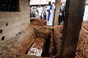 A Catholic Priest prays during a burial of one of the victims killed in an attack by gunmen during a Sunday mass service, at St. Francis Catholic Church in Owo, Ondo, Nigeria June 17, 2022.