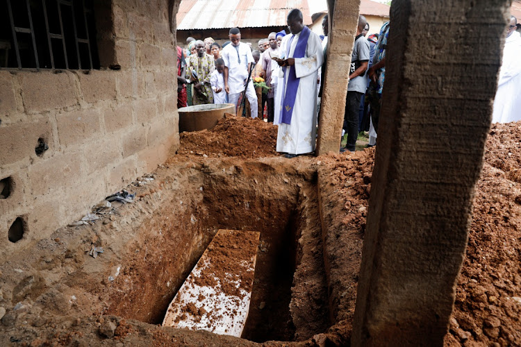 A Catholic Priest prays during a burial of one of the victims killed in an attack by gunmen during a Sunday mass service, at St. Francis Catholic Church in Owo, Ondo, Nigeria June 17, 2022.