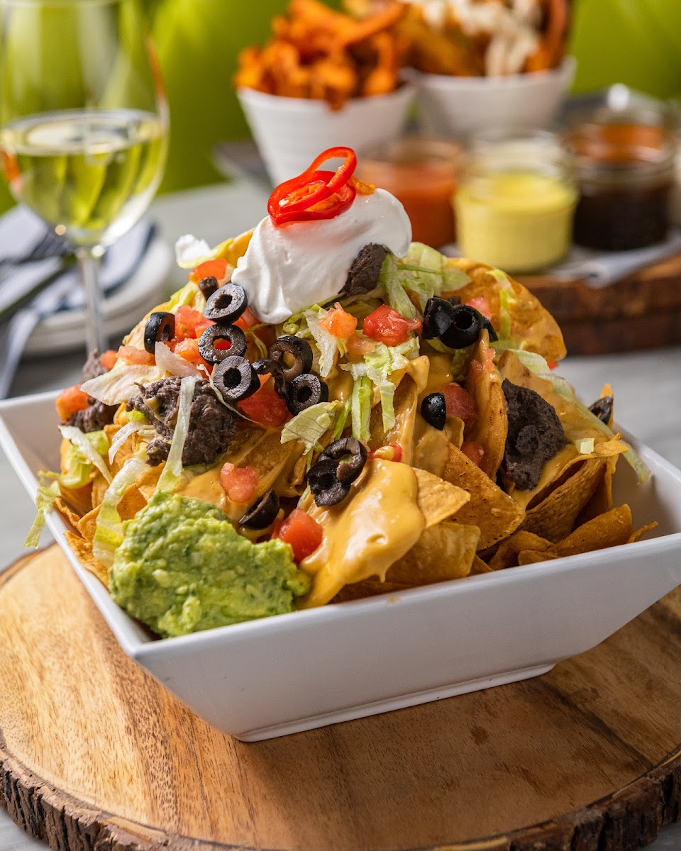 vegan nachos | 
crunchy corn chips | dairy-free queso | warm black bean puree | shredded lettuce | sliced black olives | diced, fresh tomato | smoked salsa verde | freshly squished guac | dairy-free sour cream | pickled fresno peppers