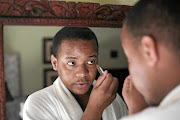 Kennedy Thabiso Molekwa does his makeup. Picture: Alaister Russell