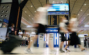 Passengers wearing protective masks walk to the check-in counters at the O.R. Tambo International Airport in Johannesburg, South Africa, December 22, 2020. 