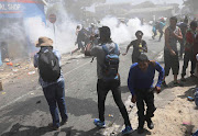 Stun grenades were used to disperse looters from a shop adjoined to a suspected drug den. 