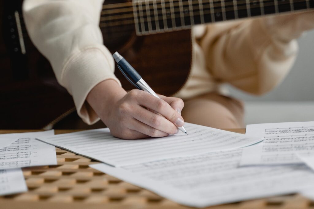 Un músico haciendo una rearmonización usando una guitarra acústica con cuerdas de acero