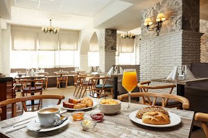 a restaurant with a table topped with plates of food and a glass of orange juice .