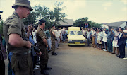 Soldiers line the road outside Chris Hani's home in Dawn Park, Boksburg as a police van prepares to take the body of the SACP leader away on April 10,1993.