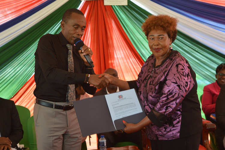 Governor Kimani Wamatangi (Left) hands over an appointment letter to Cecilia Mwangi representing Thika business community into an ad hoc committee constituted to midwife the elevation of Thika into an industrial smart city