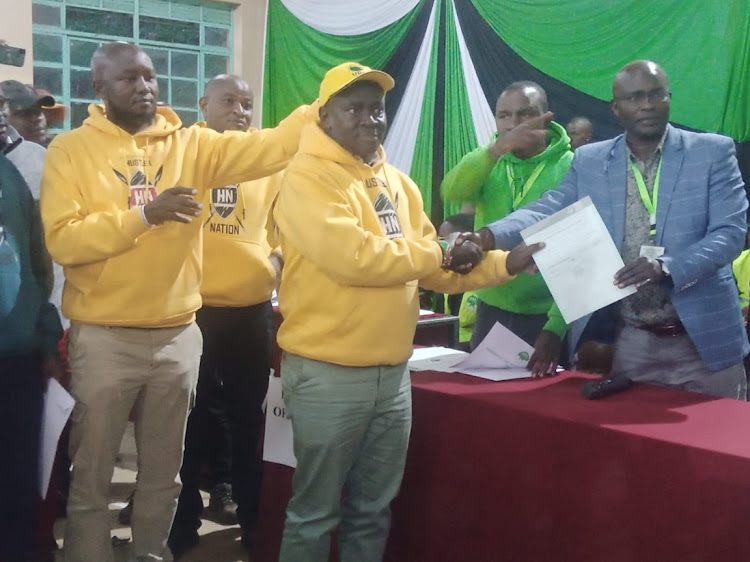 Kirinyaga central MP elect Gachoki receives his IEBC certificate from the constituency returning officer James Maingi.