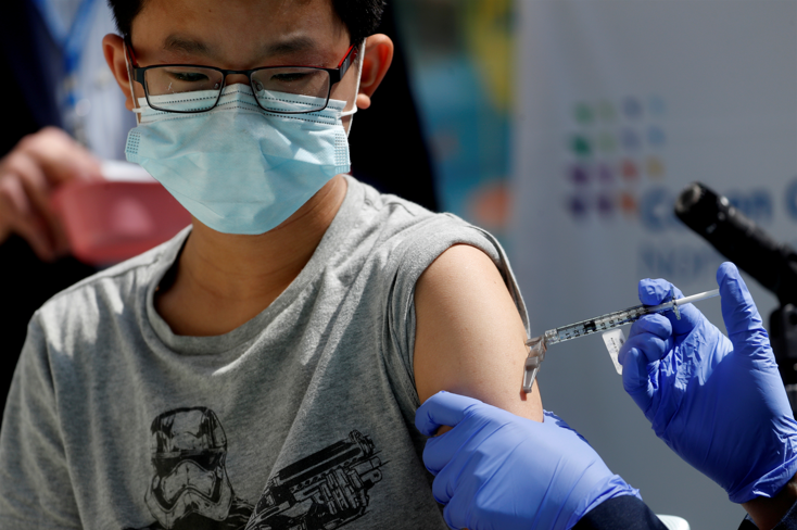 FILE PHOTO: Brendan Lo (13) receives a dose of the Pfizer-BioNTech vaccine for the coronavirus disease at Northwell Health's Cohen Children's Medical Center in New Hyde Park, New York, US, on May 13, 2021.