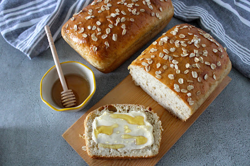 Sliced Honey Oatmeal Bread with butter and honey.