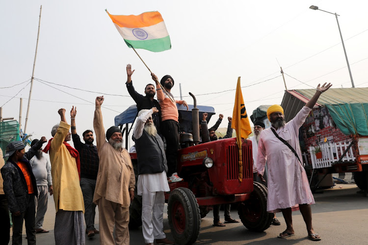 Farmers celebrate after Indian Prime Minister Narendra Modi announced that he will repeal the controversial farm laws, at the Ghazipur farmers protest site near Delhi-UP border, India, November 19 2021. Picture: REUTERS/ANUSHREE FADNAVIS