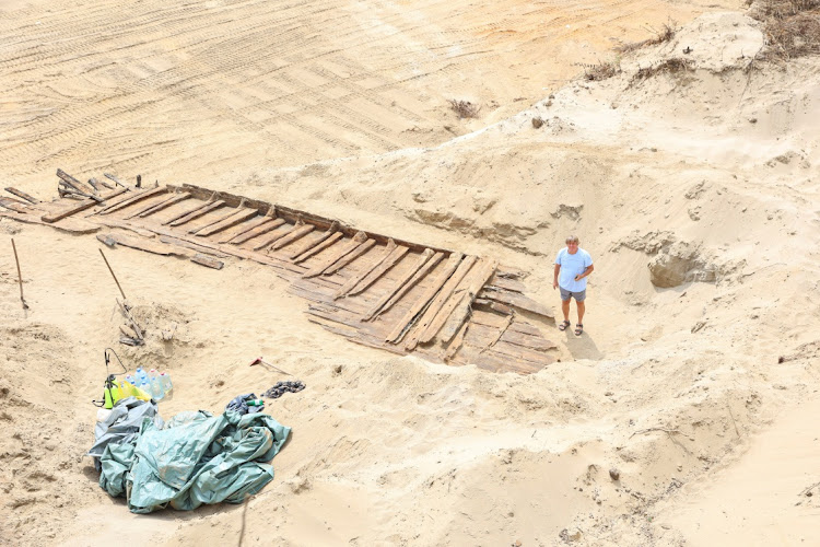 Miomir Korac, lead archaeologist, poses for a picture in front of the hull of a wooden ship, an ancient Roman flat-hulled riverine vessel at the ancient city of Viminacium, near Kostolac, Serbia, August 2, 2023.