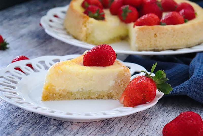 A Slice Of Cheesecake In A Blender With Fresh Strawberries.