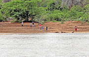 Zimbabweans wait for the level of  the   Limpopo River to  subside before they attempt to cross to SA.