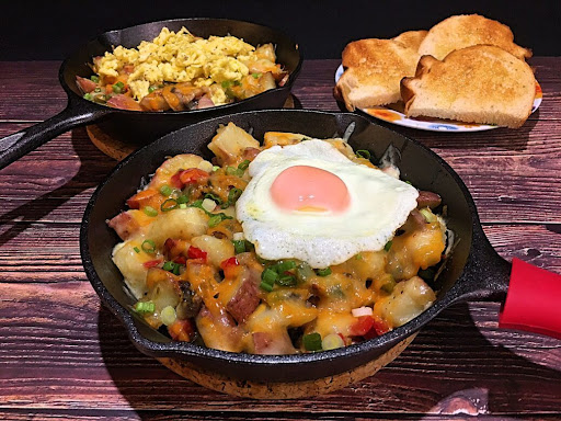 A delicious skillet loaded with deliciousness and topped with an egg.