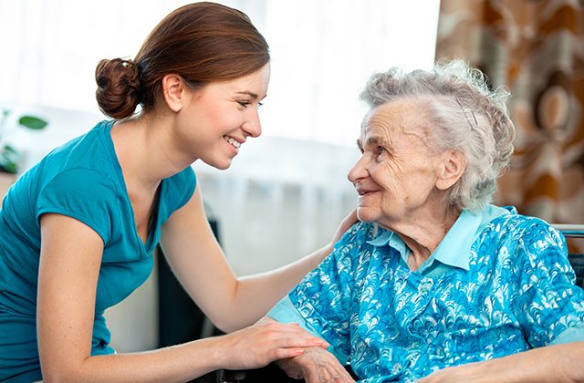 Home health care worker assisting elderly woman