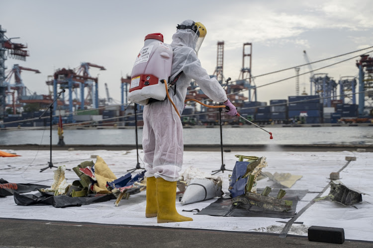 Indonesian Red Cross spray disinfectant around the debris of Sriwijaya aircraft on January 12, 2021 in Jakarta, Indonesia. Sriwijaya Air flight SJY182, carrying 62 people on board a flight from Indonesia's capital to Pontianak, Indonesia, lost contact with air controllers shortly after take-off and is believed to have crashed into the waters off the coast of Jakarta.