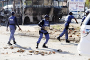 June 21, 2016. A delivery truck and a bus were set alight by angry residents of Atteridgeville, west of Pretoria. Residents brought the township to a standstill following the announcement that Parliament House Chairperson Thoko Didiza will be the mayor of Tshwane should the ANC retain the municipality later this year. Police later arrived to clean the streets while looting continued. PHOTO:PETER MOGAKI