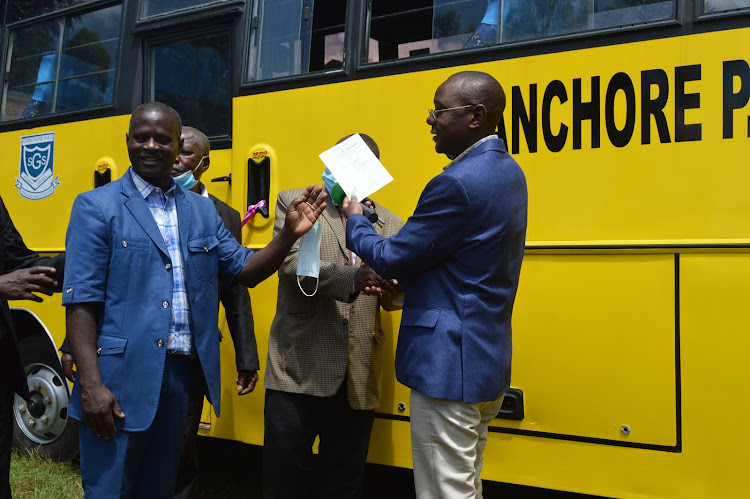 West Mugirango MP Vincent Kemosi (R) hands over a school bus to Gianchore PAG Secondary on Tuesday May 18, 2021