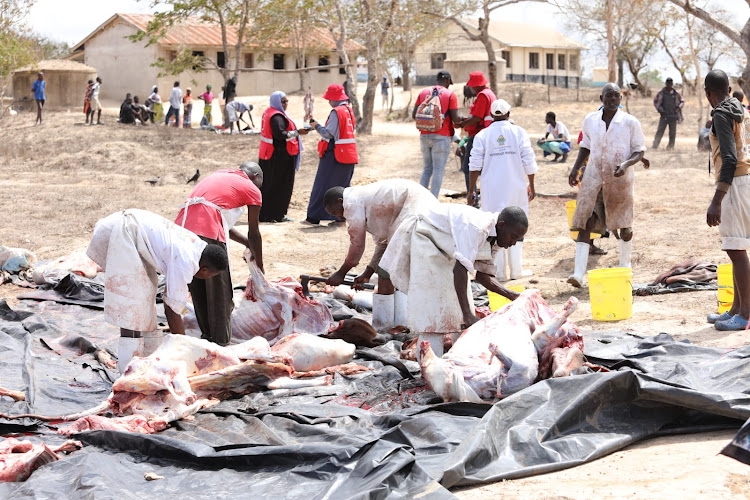 Residents of Bamba in Ganze Kilifi county and the Kenya Red Cross officials slaughter livestock during the launch of the offtake programme.