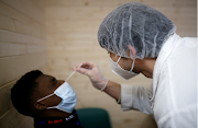 A pharmacy student, wearing a face mask, administers a nasal swab to a patient in a cabin outside a pharmacy in Nantes as the coronavirus disease outbreak continues in France, on January 5 2021.
