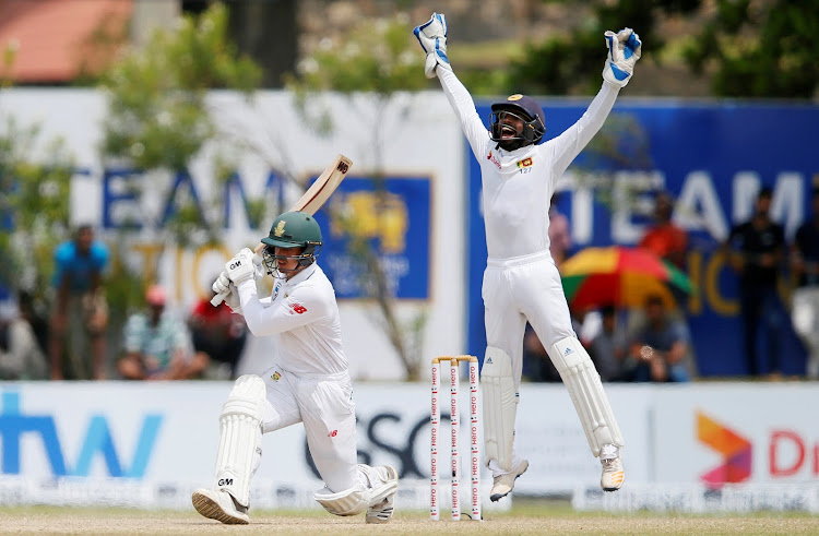 Sri Lanka's wicketkeeper Niroshan Dickwella (R) appeals for a successful LBW decision against South Africa's Quinton de Kock during the first test match in Galle, Sri Lanka on July 14, 2018.