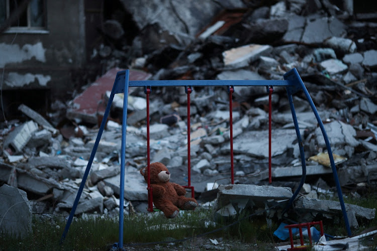 A teddy bear hangs on a swing next to a damaged building in Saltivka district, amid Russia's attack on Ukraine, in Kharkiv, Ukraine, May 17, 2022.