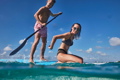 carnival-Grand-Cayman_photographer_Pip_Cowley.jpg - Paddleboarding in Grand Cayman. Escape to the warm waters of the Caribbean on a Carnival cruise.